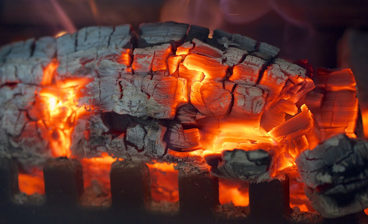An image showing hot embers glowing in a wood burning stove