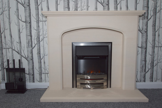An electric fire in a traditional limestone fireplace
